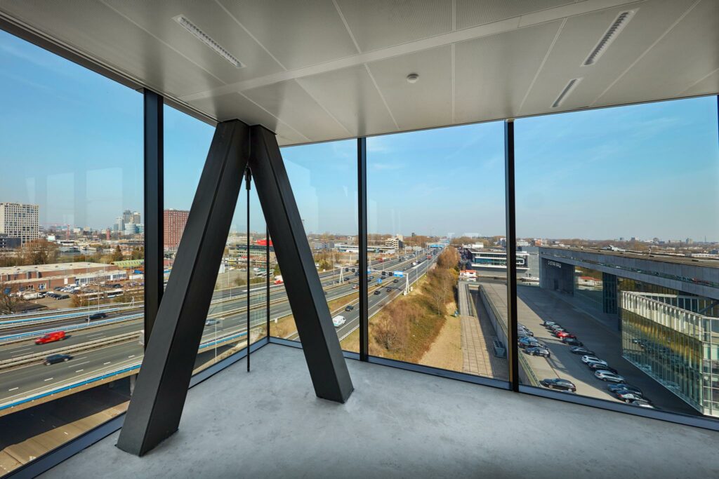 Uitzicht vanuit een kantoorpand aan de Joan Muyskenweg op de snelweg en omliggende gebouwen in Amsterdam.